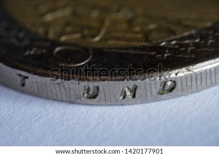 Common side of German EURO coin. Detail of the edge. Edge lettering of the €2 coin EINIGKEIT UND RECHT UND FREIHEIT (translation: unity, justice and freedom) and the emblem of the Federal Eagle.