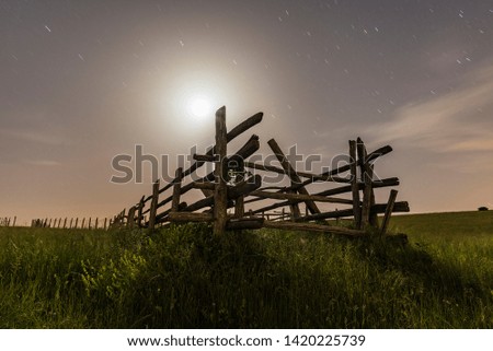 night view with starry sky, foreground wooden fence on green grass