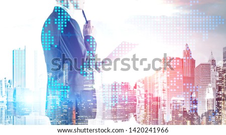Pensive businessman standing with documents and pen over cityscape background with double exposure of digital world map. Concept of leadership and international digital network. Toned image
