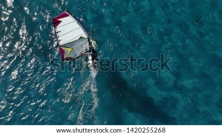 Aerial photo of wind surfer cruising in high speed in Mediterranean destination bay with deep blue
