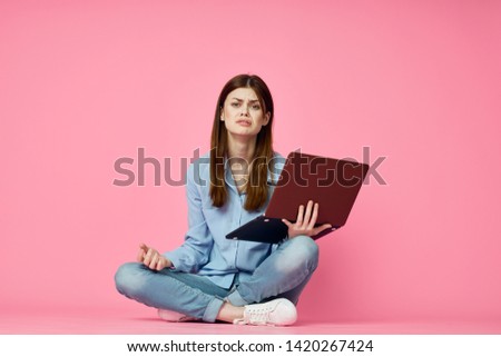 woman with laptop on a pink background