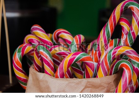 colorful candies in the form of a cane in a basket on a showcase in the Park.