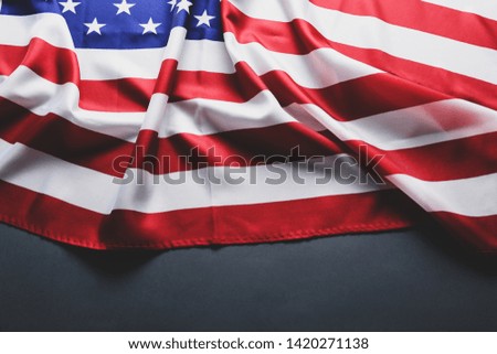 Patriotic composition w/ ruffled American flag on black background. United States of America stars & stripes symbol with copy space for text. 4th of july Independence day concept. Background, close up