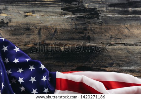 Patriotic composition w/ ruffled American flag, wood planks background. United States of America stars & stripes symbol, copy space for text. 4th of july Independence day concept. Background, close up