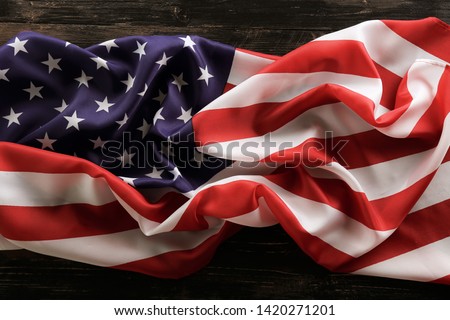 Patriotic composition w/ ruffled American flag, wood planks background. United States of America stars & stripes symbol, copy space for text. 4th of july Independence day concept. Background, close up