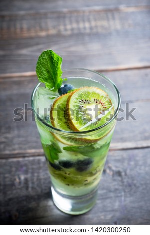 Fresh summer cocktail with blueberry and kiwi on the wooden background. Selective focus. Shallow depth of field. 