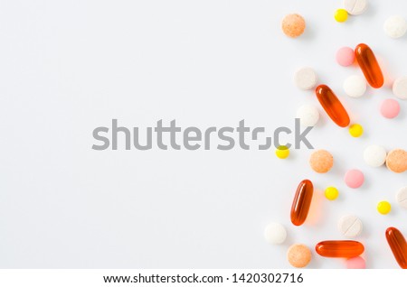 Assorted colorful tablets, pills, drugs isolated on white background. Medication and healthcare concept. Close up, copy space, selective focus. Royalty-Free Stock Photo #1420302716