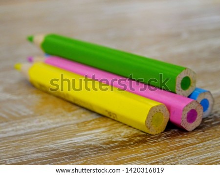 Colorful crayons for painting laid on a wooden board, school supplies
