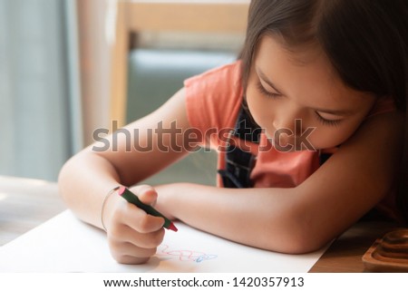 cute little girl drawing, coloring a picture; concept of child cognitive development, preschooler art education, kid's hobby