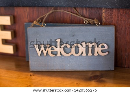 Rustic wood welcome sign hanging on wooden table