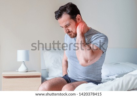 Man waking up in the morning and suffer for stiff neck Royalty-Free Stock Photo #1420378415