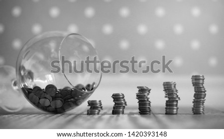 Coins in a jar on the floor. Accumulated coins on the floor. Pocket savings in piles.
