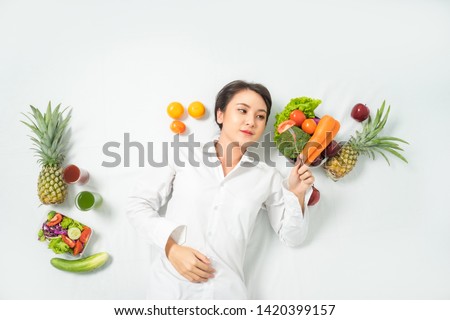 Asian woman sleeping her is love vegetables and smiling on white background. Healthy food and Diet concept.