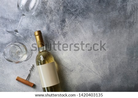 Unopened vintage bottle of white wine with blank label, empty wineglass & bunches of different grapes on wooden table background. Expensive bottle of chardonnay concept. Copy space, top view, flat lay Royalty-Free Stock Photo #1420403135