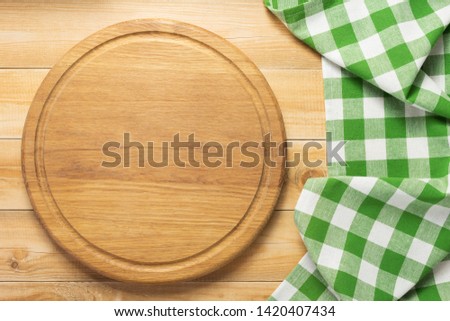 pizza cutting board and naplin at rustic wooden plank background, top view