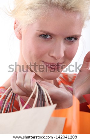 Closeup of a young blond woman carrying shopping bags