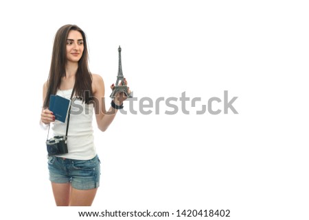 Woman with camera and passports holding eiffel tower