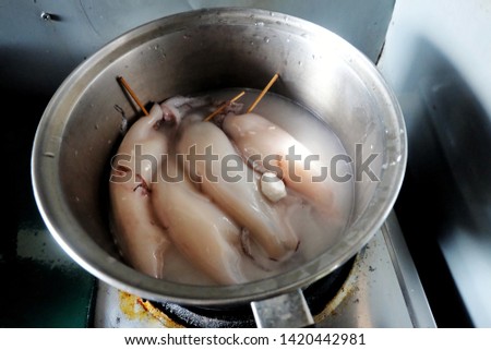 A noise picture of squids been boiled for "ketupat sotong" or sticky rice in squid.
