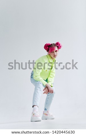 woman with pink hair sits on a cube