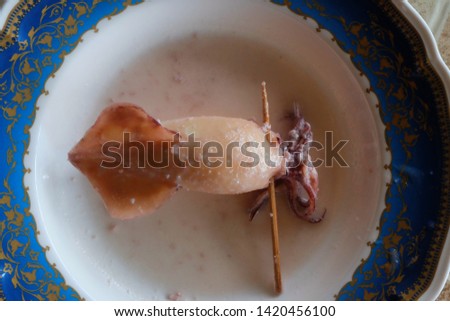 A flatlay picture of "ketupat sotong" or sticky rice in squid. Famous in East Coast of Malaysia.