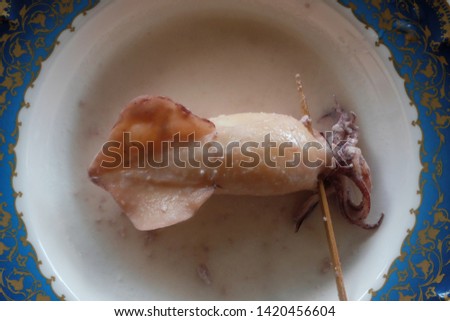 A flatlay picture of "ketupat sotong" or sticky rice in squid. Famous in East Coast of Malaysia.