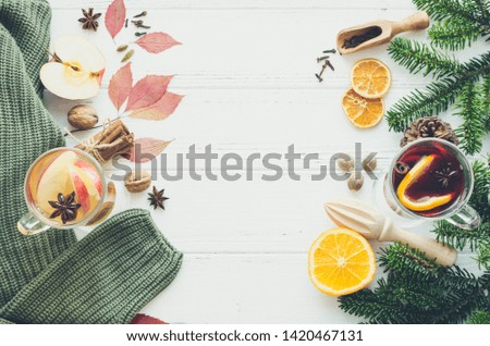 Autumn mulled wine with apple based on white wine ws Christmas mulled wine based on red wine with orange and Christmas spices on white wooden background. Seasonal and holidays. Top view. Copy space.