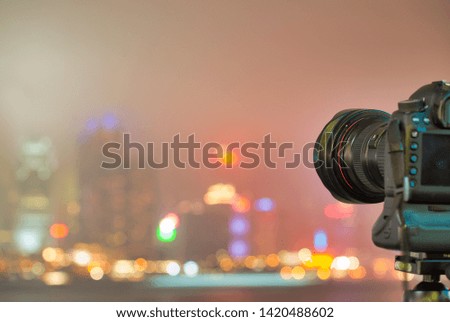 Camera on tripod making automatic pictures of amazing city skyline at night. Skyscrapers lights.