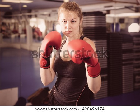 Portrait of  positive french  woman who is training in box gym.