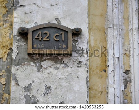 House number plate on the wall of the old building.