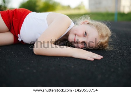little girl lying on floor outdoors