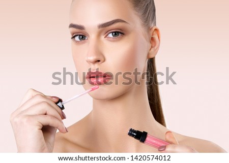 Beautiful woman applying lipstick. Beauty concept Royalty-Free Stock Photo #1420574012