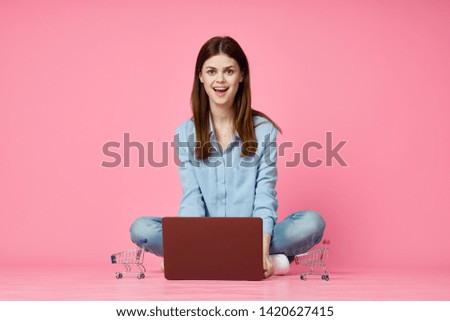 student with laptop on pink background