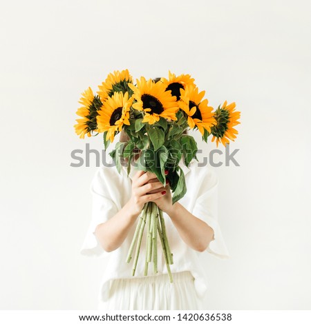 Young girl with sunflowers bouquet in hands on white background. Summer floral composition.