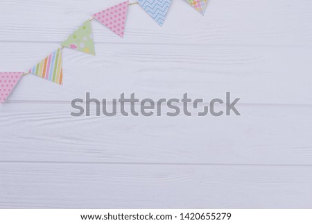 Birthday decorative flags on white wood. Colorful triangle DIY party flags on rope over wooden background with copy space.