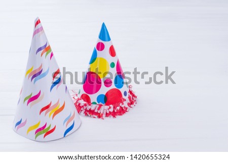 Two patterned party hats. Cardboard Birthday party caps for kids on white background with copy space. Holiday invitation background.