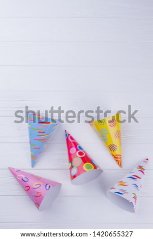 Patterned party hats with copy space. Assorted Birthday caps. White wooden background with text space.
