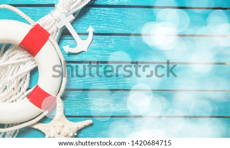 Decorative Lifebuoy and anchor on blue wooden planks background