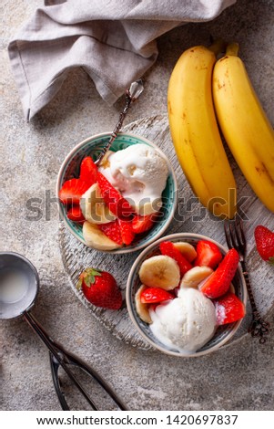 Summer fruit salad with strawberry, banana and ice cream