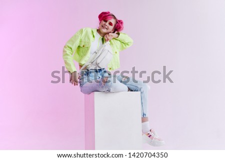 retro style spotlight color woman with pink hair sitting on a cube