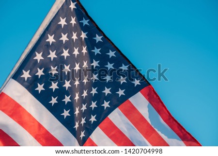 American flag in blue sky. close up. Symbol of Independence Day fourth of July in USA