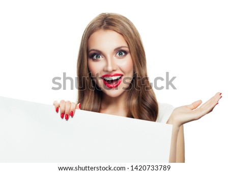 Happy surprised model woman showing open hand and holding white empty paper signboard isolated on white background 