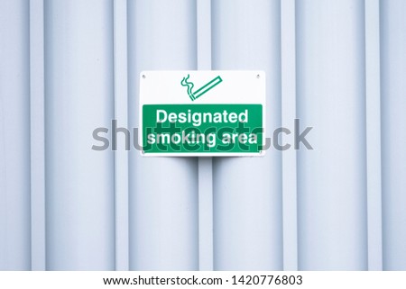 Designated smoking area sign outdoors at work place