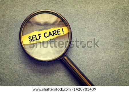 top view of magnifying glass with self care inscription on table