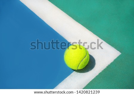 Summer sport concept with tennis ball on white line on hard tennis court. Flat lay, top view, copy space, close up. Classic Blue color of the 2020 year.  Blue, green and yellow. Royalty-Free Stock Photo #1420821239