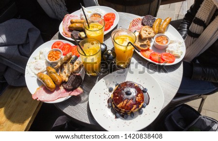 Delicious English breakfast shot in a London restaurant (England). Fresh orange juice, pancakes & blueberries, sausages, tomatoes, eggs, beans, fresh bread and more ! Sharp and colorful picture.