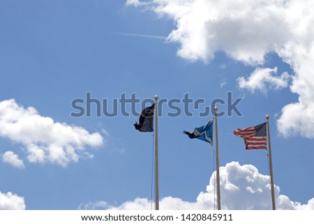 Scotland and American flags flying on flagpoles at St Andrews Scotland. Blue sky and clouds. 