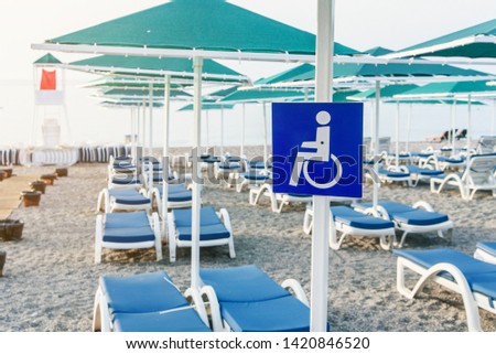 Wheelchair sign set on the beach near the sea. Rest place for people with disabilities.
