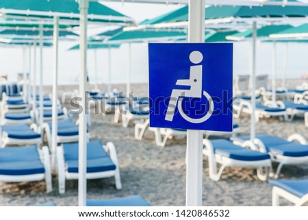 Close up disability sign on the sea beach. Marking a place for rest to a persons with a disability on the beach.