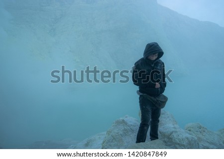 Young portrait wearing mask at biggest crater lake volcano of Kawah Ljen in east java, Indonesia, (Visible noise due to high ISO, soft focus)