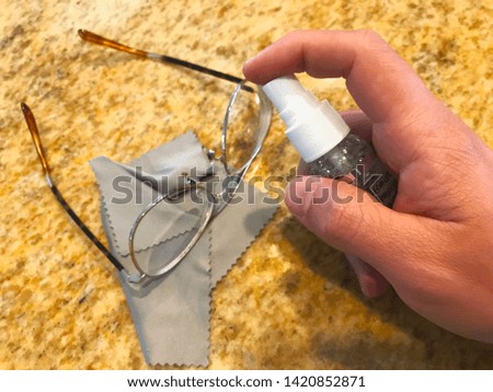A pair of reading glasses being cleaned. Microfiber cloths are the way to go.